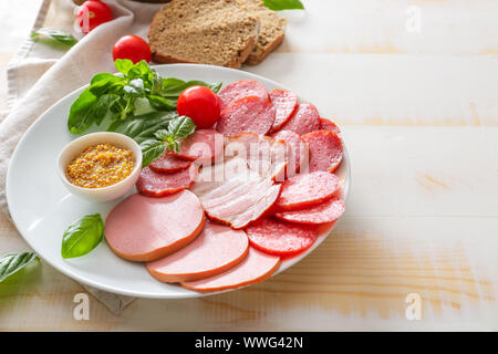 Mit Sortiment an Wurst, Soße und Brot auf der Tischplatte Stockfoto