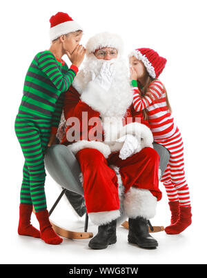 Kleine Kinder sagen Santa ihre Wünsche vor weißem Hintergrund Stockfoto