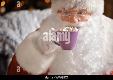 Santa Claus trinken heiße Schokolade am Heiligabend Stockfoto