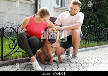 Sportliches Paar mit niedlichen Hund wandern im Freien Stockfoto