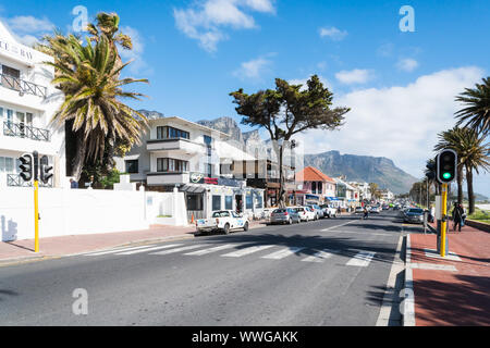 Camps Bay, exklusiven Vorort von Kapstadt, Südafrika, den Blick von der Hauptstraße in Geschäften, Restaurants und Wohnhäuser an einem Frühlingstag Stockfoto