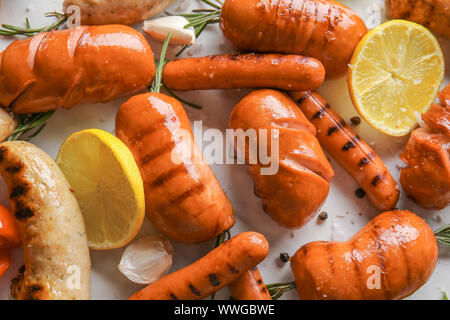 Auswahl an leckeren gegrillten Würstchen auf hellen Hintergrund Stockfoto