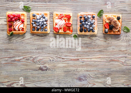 Verschiedene süße Waffeln mit Beeren ein Eis auf hölzernen Tisch Stockfoto