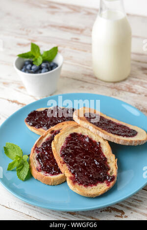 Teller mit leckeren Toast und Marmelade auf weißen Tisch Stockfoto