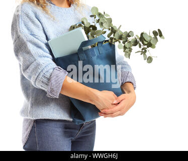 Frau mit Buch und Eukalyptus in eco Beutel auf weißem Hintergrund, Nahaufnahme Stockfoto