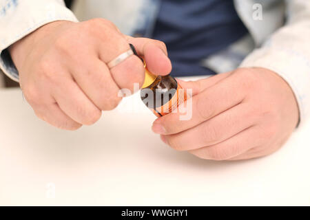 Bild des Mannes Tropfen Medizin Flasche in der Hand halten. Auf weissem Hintergrund. Stockfoto