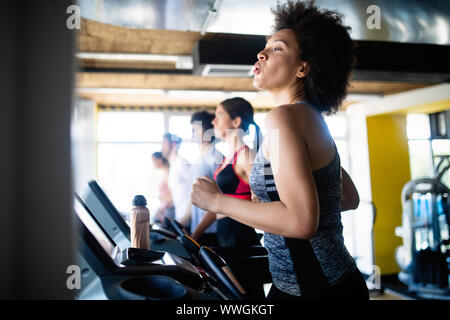 Gruppe von jungen Menschen, die auf Laufband im Fitnessstudio Stockfoto