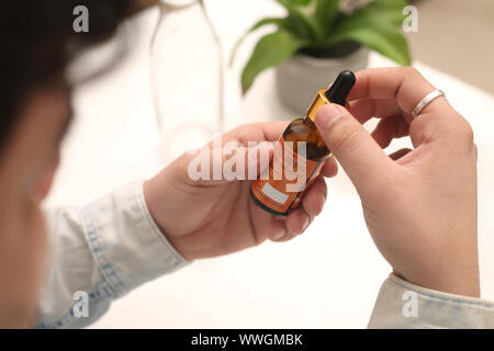 Bild des Mannes Tropfen Medizin Flasche in der Hand halten. Auf weissem Hintergrund. Stockfoto