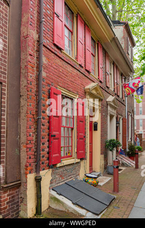 Hellen roten Fensterläden Frame die Fenster von einem Haus im historischen Elfreth's Alley, die älteste ständig bewohnte Straße in die USA zurück zu 1702 dating Stockfoto