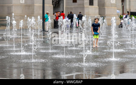 Ein kleiner Junge beim Spielen im Brunnen in Dilworth Park von Philadelphia City Hall Stockfoto