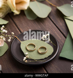 Nahaufnahme von kreativen goldene Hochzeit Ringe auf kleine schwarze Platte Stockfoto
