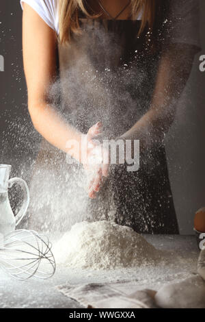 Frau Händeklatschen mit Mehl in der Küche Stockfoto