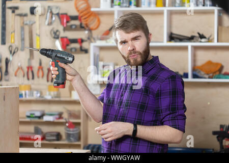 Junge bärtige Mann an der Möbelfabrik arbeiten Stockfoto