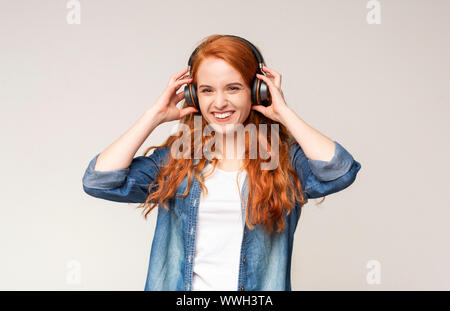 Fröhliches Mädchen, das Hören von Musik, das Tragen von kabelloser Kopfhörer Stockfoto