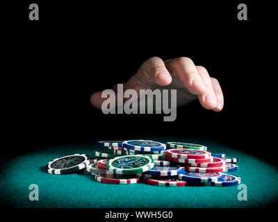 Eine Hand, etwa um einen großen Stapel Chips zu Rechen. Stockfoto