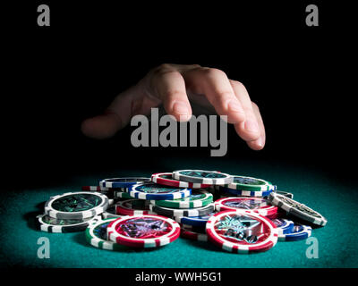 Eine Hand, etwa um einen großen Stapel Chips zu Rechen. Stockfoto