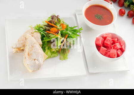 Thunfisch und Käse Sandwich mit Frischer gemischter Salat, Wassermelone und Gazpacho Suppe seitlich, mit frischem Gemüse auf Hintergrund, mehr leckeres Essen auf Stockfoto