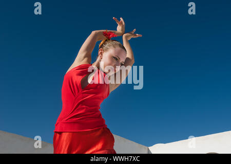 Attraktive Flamencotänzerin, die traditionellen rotes Kleid mit Blume im Haar tragen Stockfoto