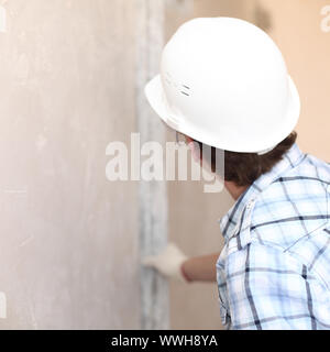 Arbeiter richtet Wand für die Leitung Stockfoto