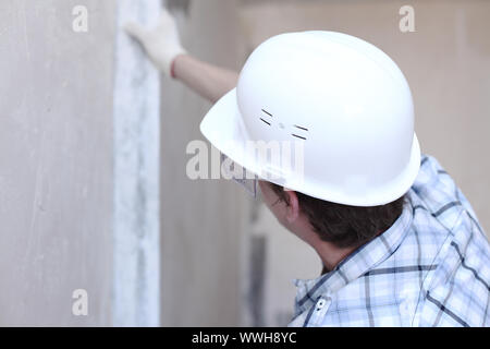 Arbeiter richtet Wand für die Leitung Stockfoto