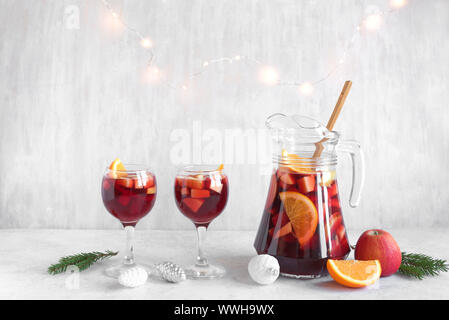 Weihnachten Sangria oder Punch in Gläser und Krug. Hausgemachten Rotwein Obst Sangria und Weihnachten festliches Dekor auf weißem Hintergrund, kopieren. Stockfoto