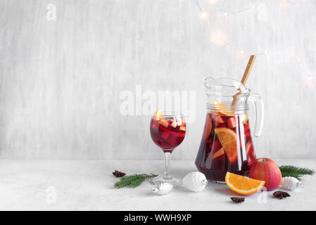 Weihnachten Sangria oder Punch in Gläser und Krug. Hausgemachten Rotwein Obst Sangria und Weihnachten festliches Dekor auf weißem Hintergrund, kopieren. Stockfoto