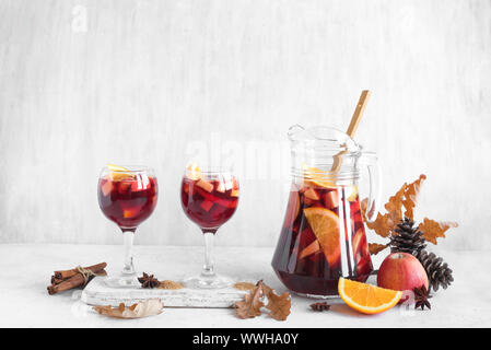 Herbst Sangria oder Punch in Krug. Hausgemachten Rotwein Obst Sangria und gelbe Herbstliche Blätter auf weißem Hintergrund, kopieren. Stockfoto