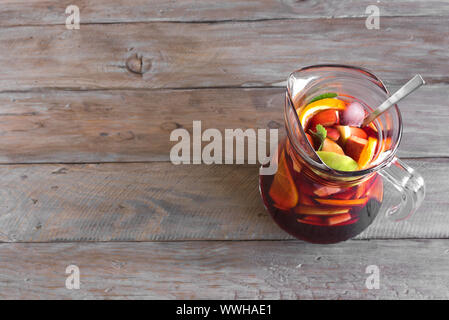 Rotwein Sangria oder Lochen mit Früchten und Eis im Krug. Selbstgemachte erfrischende Frucht Sangria auf hölzernen Hintergrund, kopieren. Stockfoto