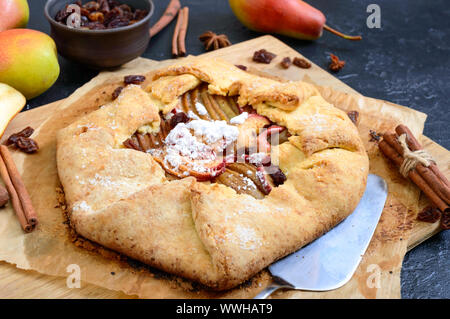 Karamellisierten Birnen Kuchen mit Zimt und Rosinen auf schwarzem Hintergrund. Leckere und einfache Dessert. Stockfoto