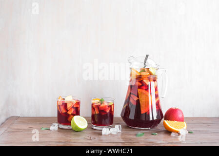 Rotwein Sangria oder Lochen mit Früchten und Eis in Gläsern und kneifer. Selbstgemachte erfrischende Frucht Sangria auf weißem Hintergrund, kopieren. Stockfoto