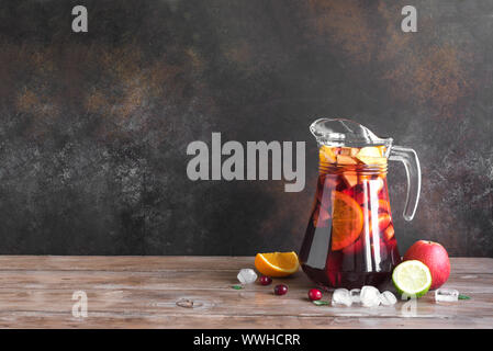 Rotwein Sangria oder Lochen mit Früchten und Eis im Krug. Selbstgemachte erfrischende Frucht Sangria auf hölzernen Hintergrund, kopieren. Stockfoto