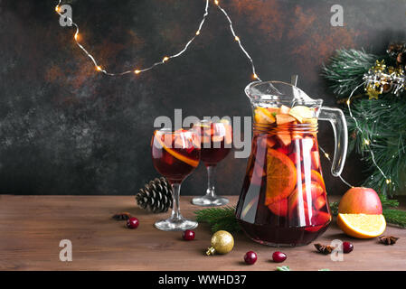Weihnachten Sangria oder Punch in Gläser und Krug. Hausgemachten Rotwein Obst Sangria und Weihnachten festliches Dekor auf Holz- Hintergrund, kopieren. Stockfoto