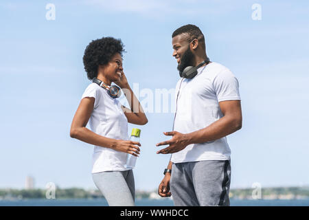 Der Mann und die Frau mit dem Sprechen, nachdem Sie morgens Joggen in der Nähe des Flusses Stockfoto
