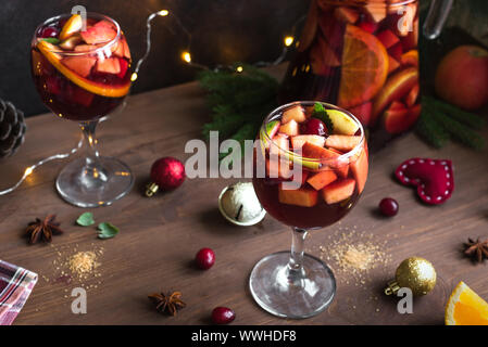 Weihnachten Sangria oder Punch in Gläser und Krug. Hausgemachten Rotwein Obst Sangria und Weihnachten festliches Dekor auf Holz- Hintergrund, kopieren. Stockfoto