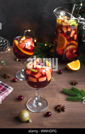 Weihnachten Sangria oder Punch in Gläser und Krug. Hausgemachten Rotwein Obst Sangria und Weihnachten festliches Dekor auf Holz- Hintergrund, kopieren. Stockfoto
