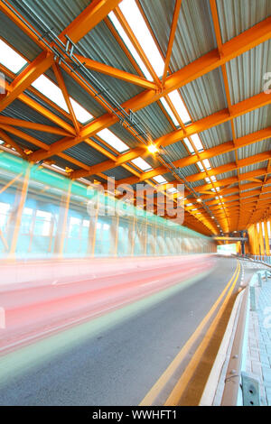 Orange Tunnel tagsüber mit beweglichen Bus Stockfoto