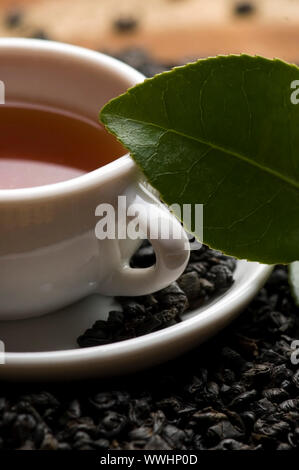 Eine Tasse grüner Tee mit mittelgewichtig Blätter Stockfoto