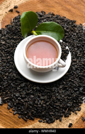 Eine Tasse grüner Tee mit mittelgewichtig Blätter Stockfoto