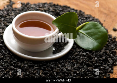 Eine Tasse grüner Tee mit mittelgewichtig Blätter Stockfoto