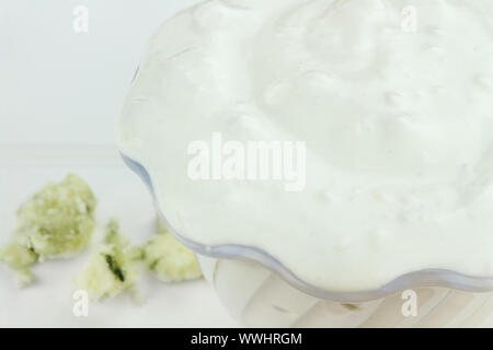 Schüssel mit frisch zubereiteten Blau Käse Salat Dressing mit Klumpen des blauen Käse im Hintergrund. Stockfoto