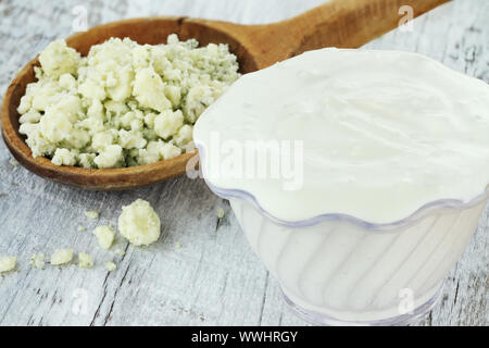 Schüssel mit frisch zubereiteten Blau Käse Salat Dressing mit Klumpen des blauen Käse in Löffel aus Holz auf einem urigen Hintergrund. Stockfoto