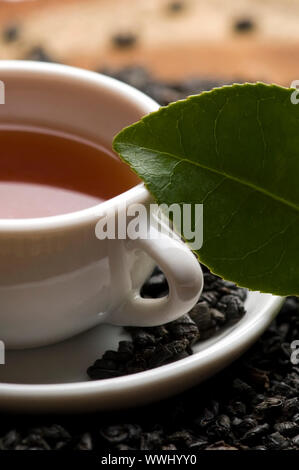 Eine Tasse grüner Tee mit mittelgewichtig Blätter Stockfoto