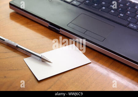 Moderner Schreibtisch mit Laptop-Stift und Visitenkarte Stockfoto