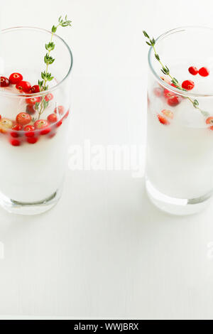 Weihnachten und Thanksgiving vegan alkoholfreien Cocktail white coconut Margarita oder Durchschlag mit Preiselbeeren und Zweig Thymian close-up Stockfoto