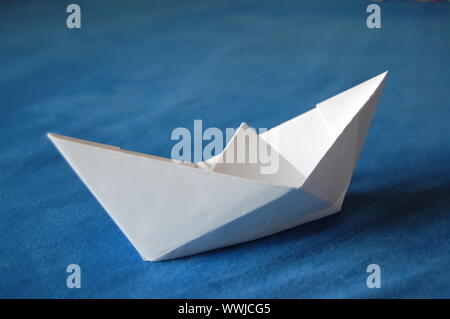 Origami Papier Boot auf blaues Wasser isoliert Stockfoto