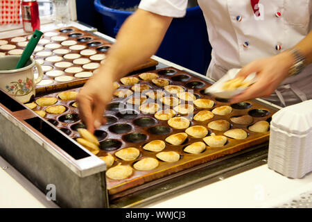 Köstliche authentische Niederländische Lebensmittel aus den Niederlanden poffertjes genannt, das sind kleine Pfannkuchen, die auf eine typische heiße Platte vorbereitet, während Cook ist Co Stockfoto