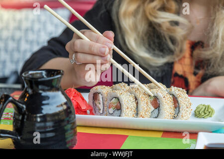 Frau Sushi mit Stäbchen zu essen Stockfoto