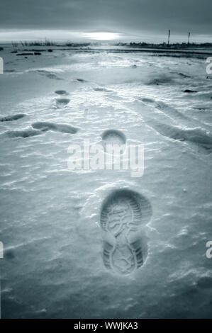 Footprint auf weißem Schnee Männer gehen zu Sun Stockfoto