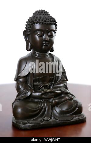 Kleine schwarze Buddha Skulptur über rote Holz Tisch Stockfoto