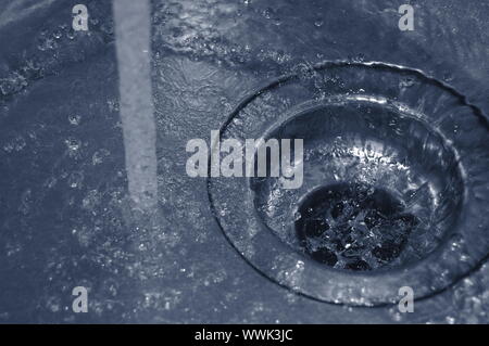 Wasserdurchfluss in den Abfluss in der Küche Stockfoto